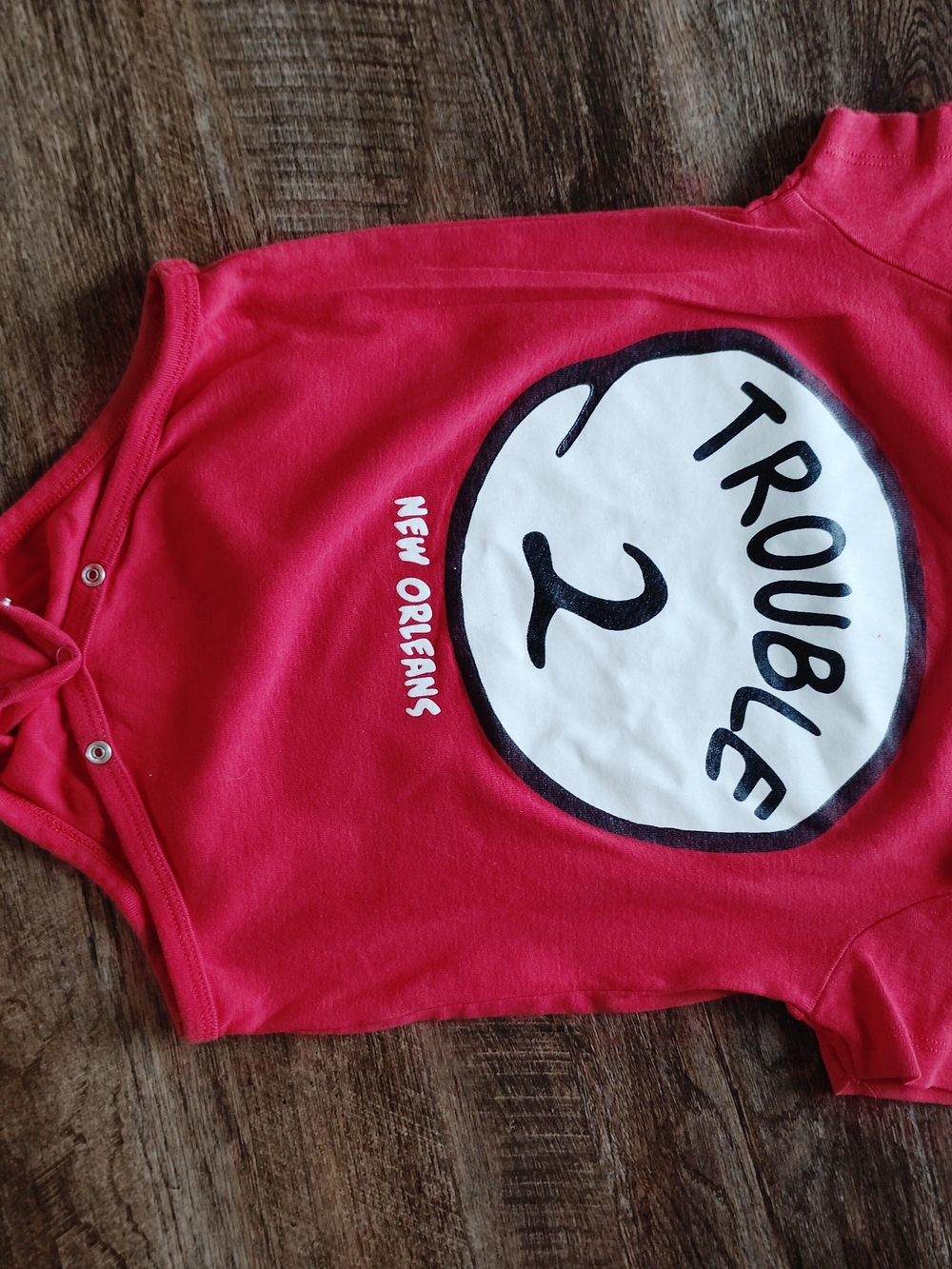 Red 'Trouble 2' Graphic Baby Bodysuit - New Orleans